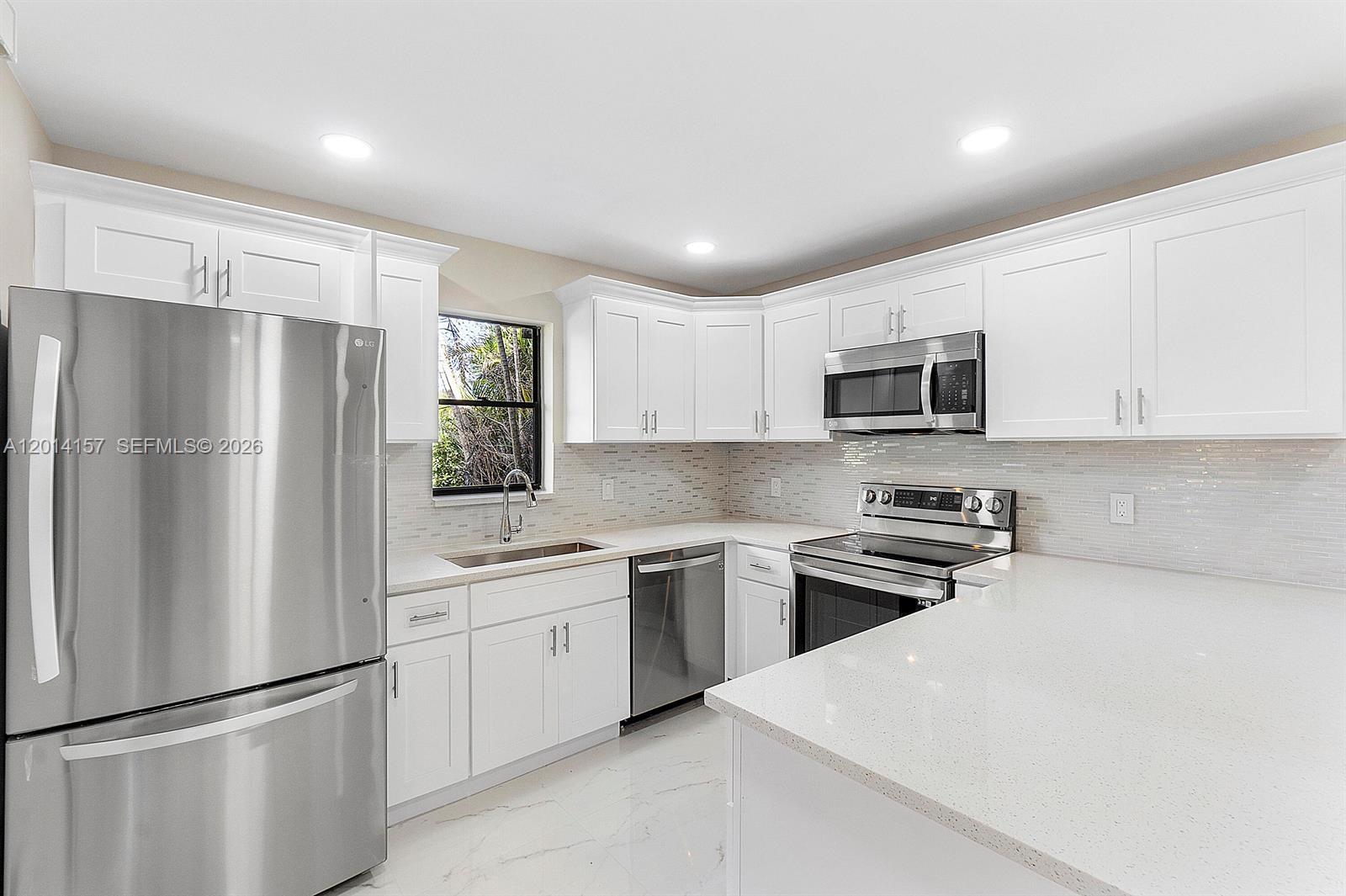 7744 Courtyard Run West Boca Raton, FL 33433 - Photo 1 of 25 a kitchen with stainless steel appliances granite countertop a refrigerator a stove a sink a microwave a refrigerator and white cabinets