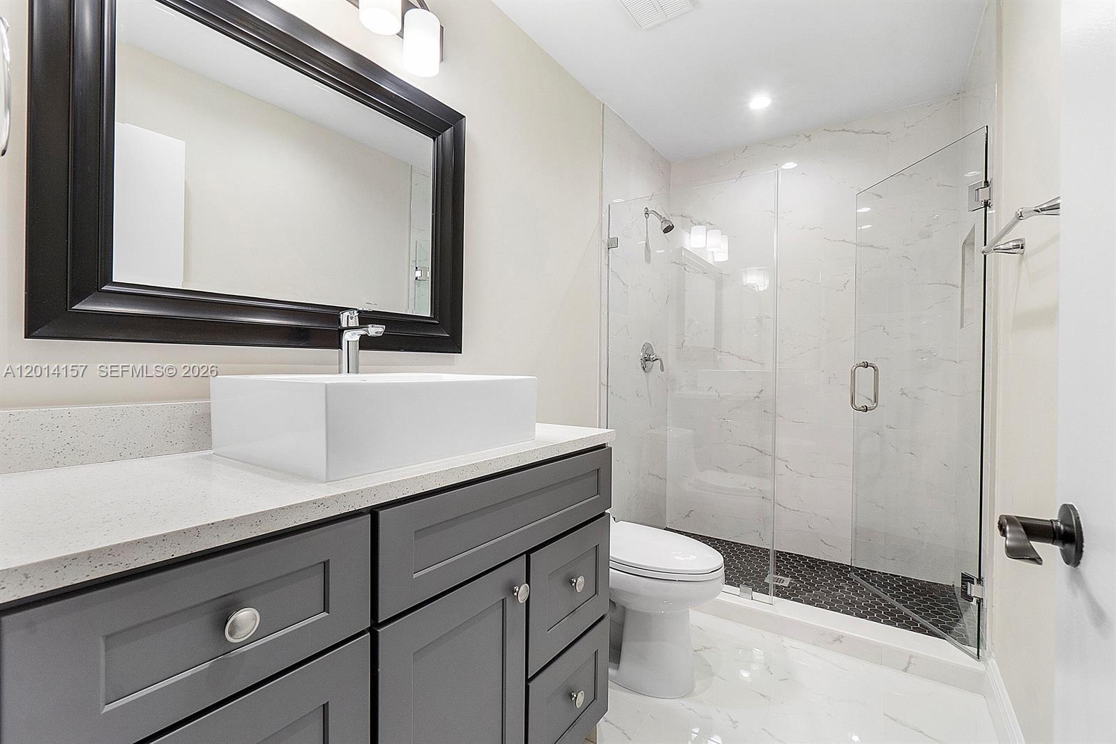 7744 Courtyard Run West Boca Raton, FL 33433 - Photo 16 of 25 a bathroom with a sink a toilet a mirror and shower