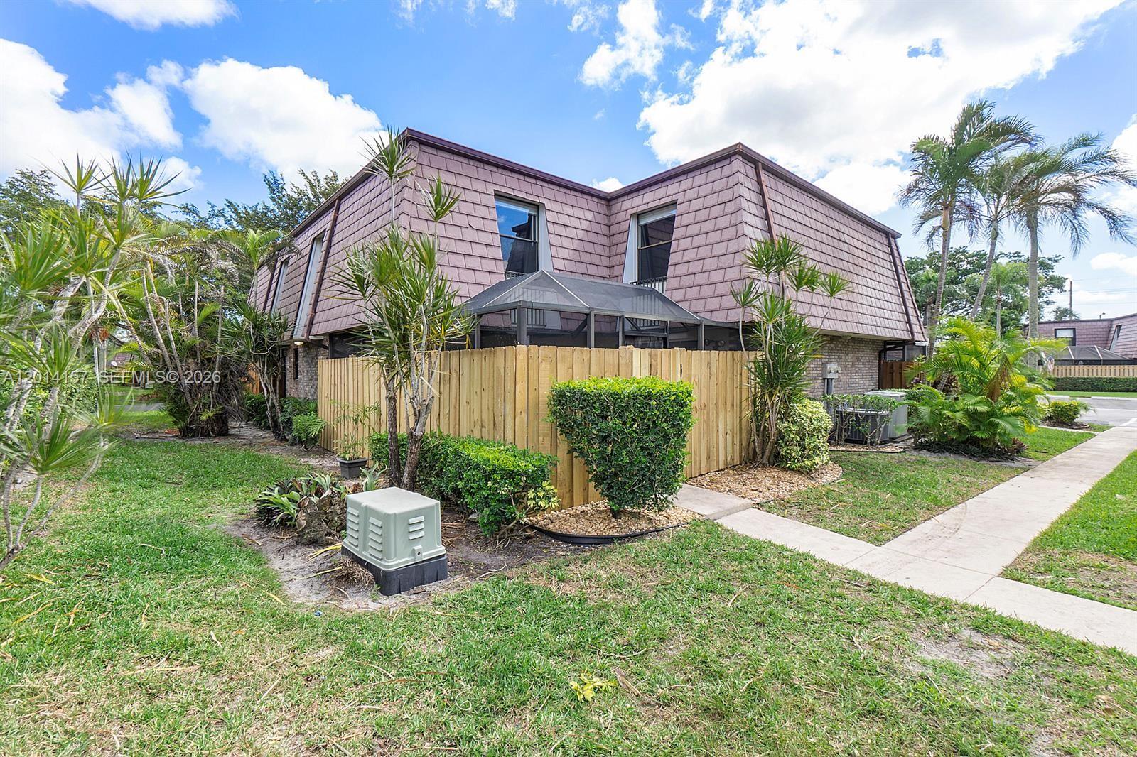7744 Courtyard Run West Boca Raton, FL 33433 - Photo 21 of 25 a front view of a house with a garden and plants