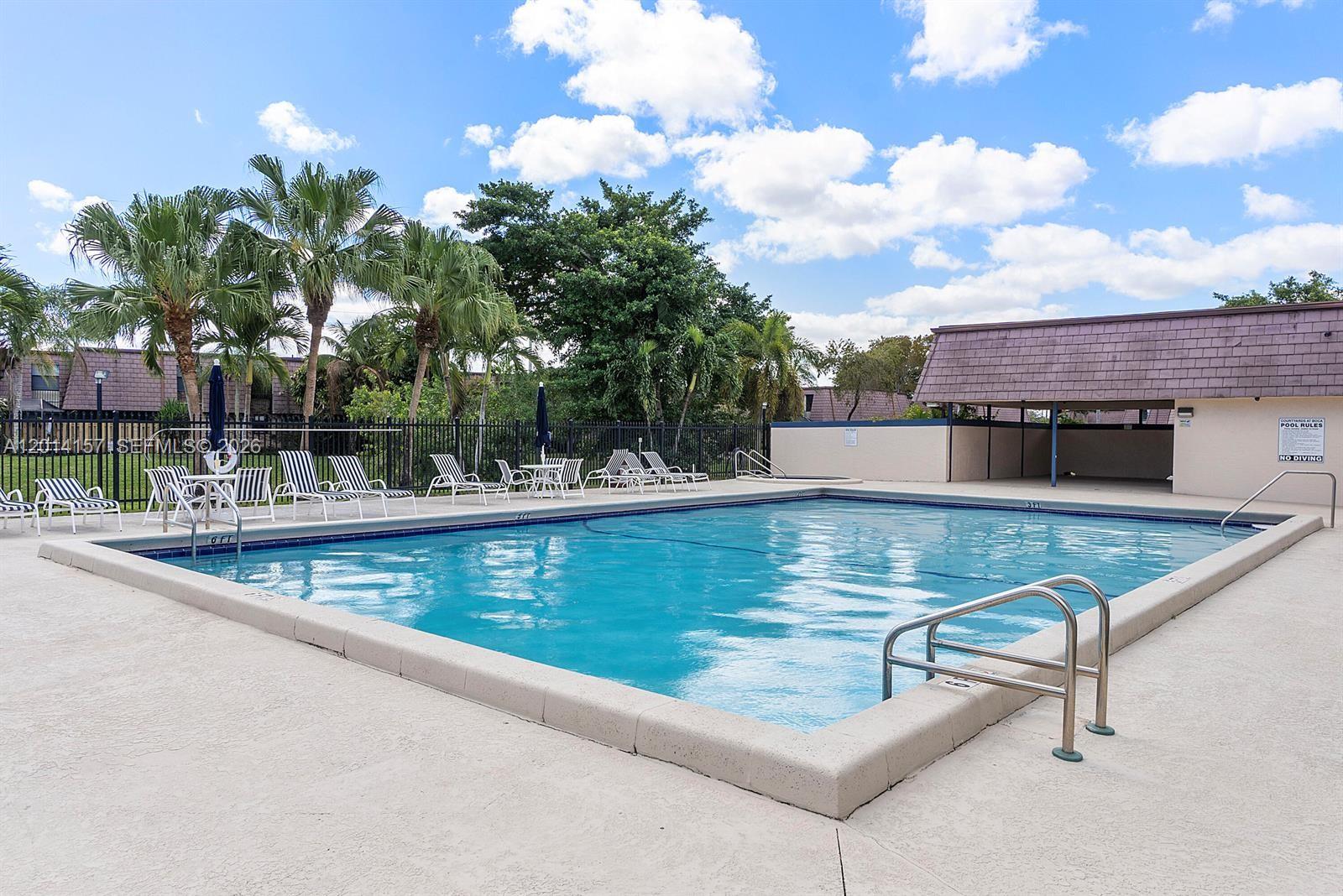 7744 Courtyard Run West Boca Raton, FL 33433 - Photo 23 of 25 a view of a swimming pool with a chair and tables in the patio