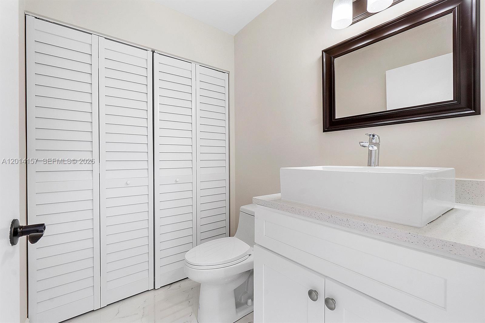 7744 Courtyard Run West Boca Raton, FL 33433 - Photo 7 of 25 a bathroom with a toilet a sink and mirror