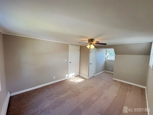an empty room with closet and a chandelier fan