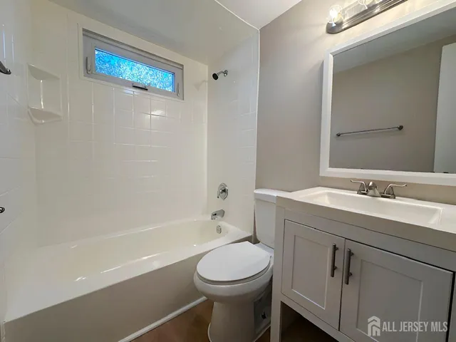 a bathroom with a toilet a sink a mirror and a bathtub