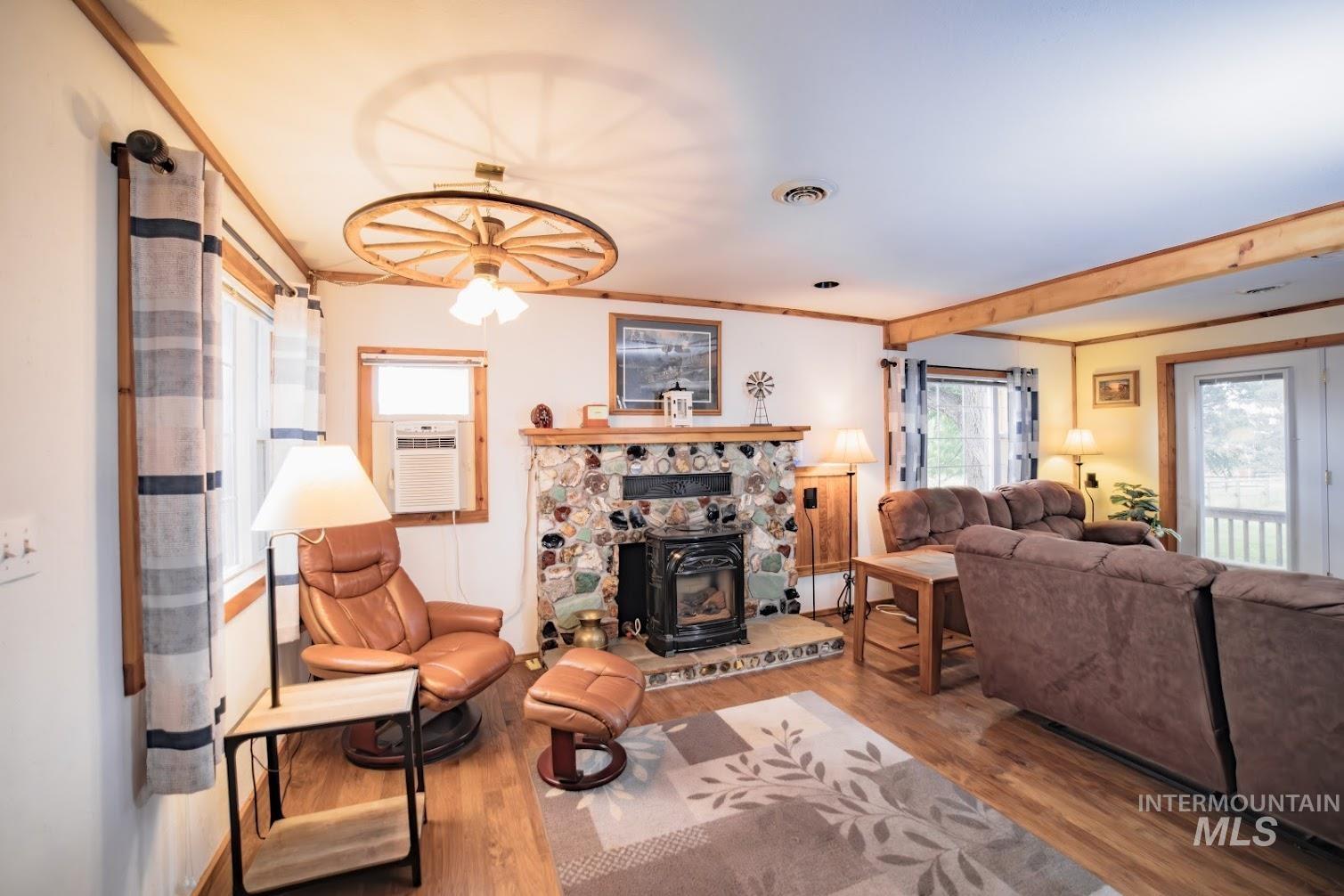 69431 Antles Road, Unit 1 Cove, OR 97824 - Photo 5 of 23 Living area with crown molding, wood finished floors, a wood stove, and beamed ceiling