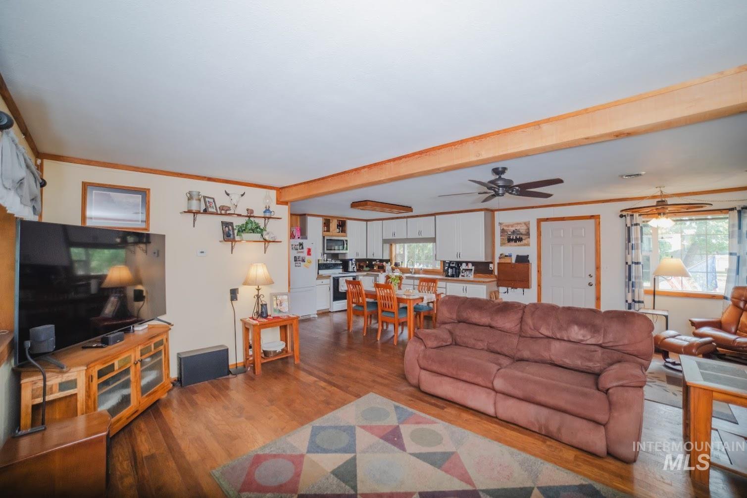 69431 Antles Road, Unit 1 Cove, OR 97824 - Photo 6 of 23 Living area with crown molding, wood finished floors, beam ceiling, and ceiling fan