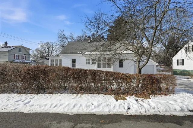 a front view of a house with a yard covered with snow