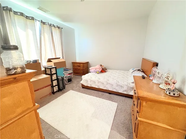 a bedroom with a bed and large windows