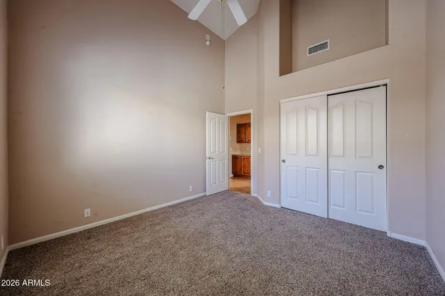 an empty room with closet and a chandelier fan