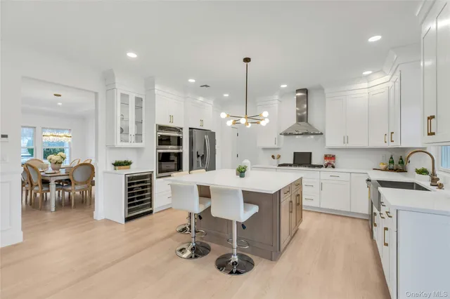 a kitchen with stainless steel appliances kitchen island granite countertop a table chairs sink and cabinets