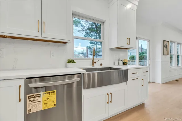 a kitchen with stainless steel appliances white cabinets and a window
