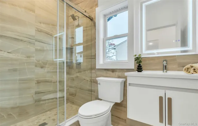 a bathroom with a sink a toilet and shower