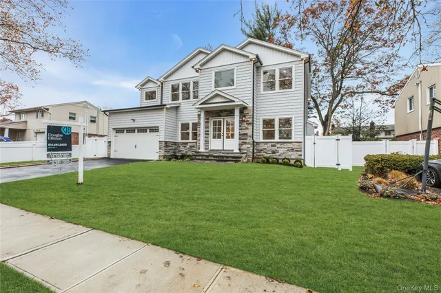a front view of a house with a garden and trees