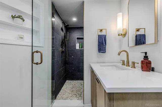 a bathroom with a sink vanity and shower