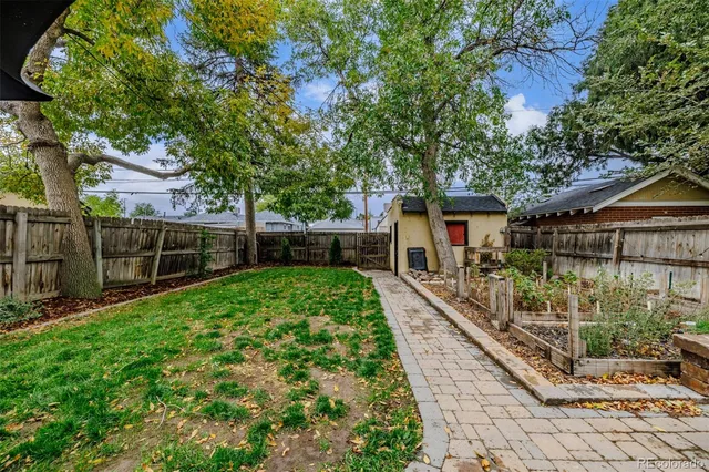 a view of house with backyard and a garden