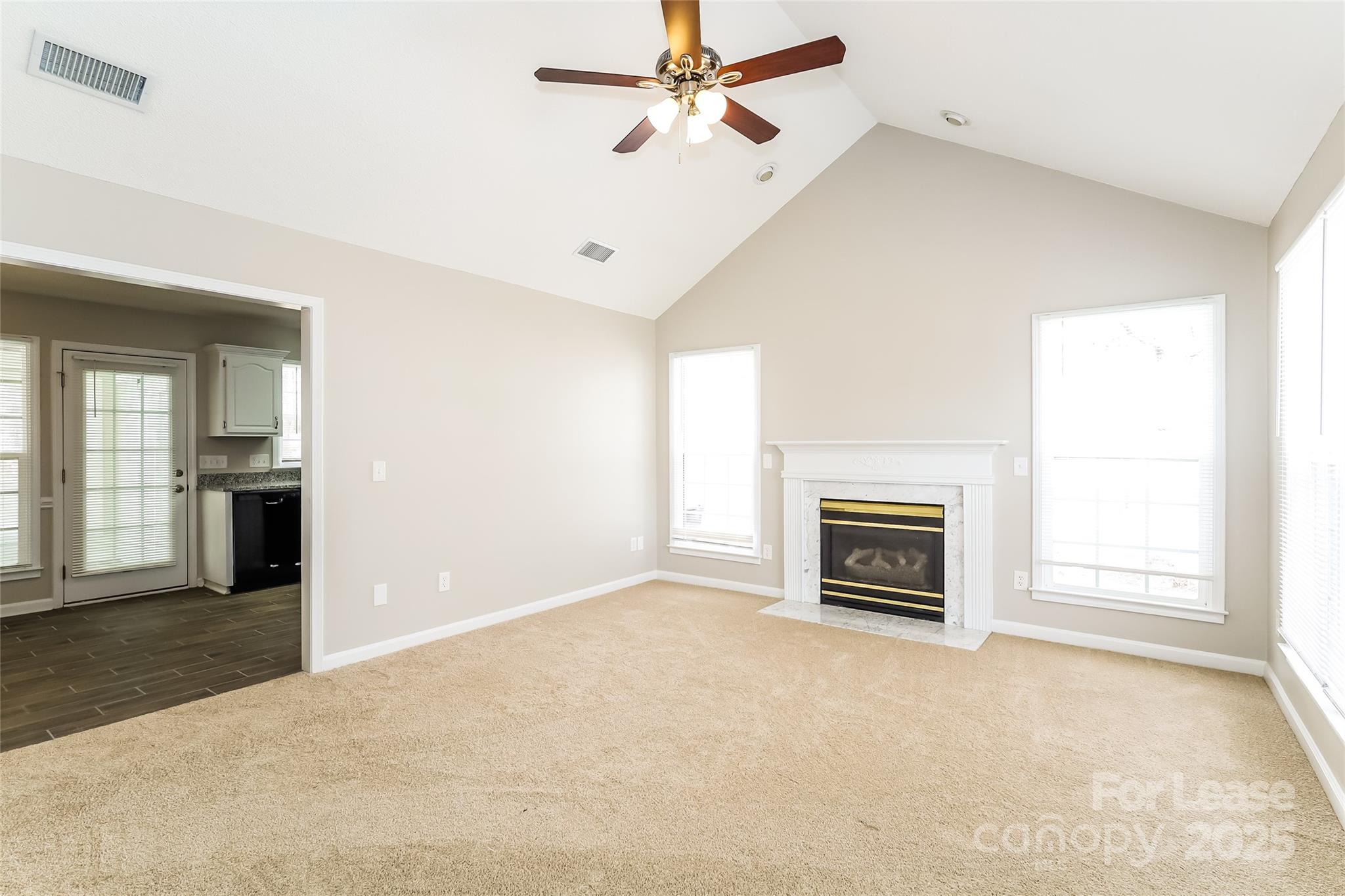 1323 Tucker Road Monroe, NC 28110 - Photo 2 of 16 an empty room with windows and fireplace