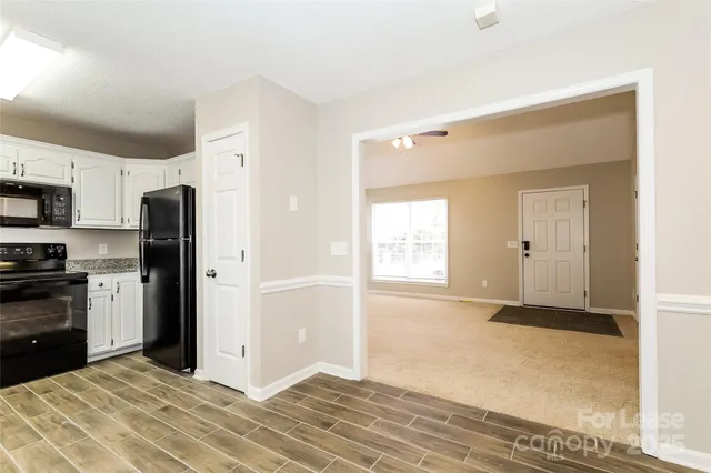 a view of a kitchen with wooden floor and electronic appliances