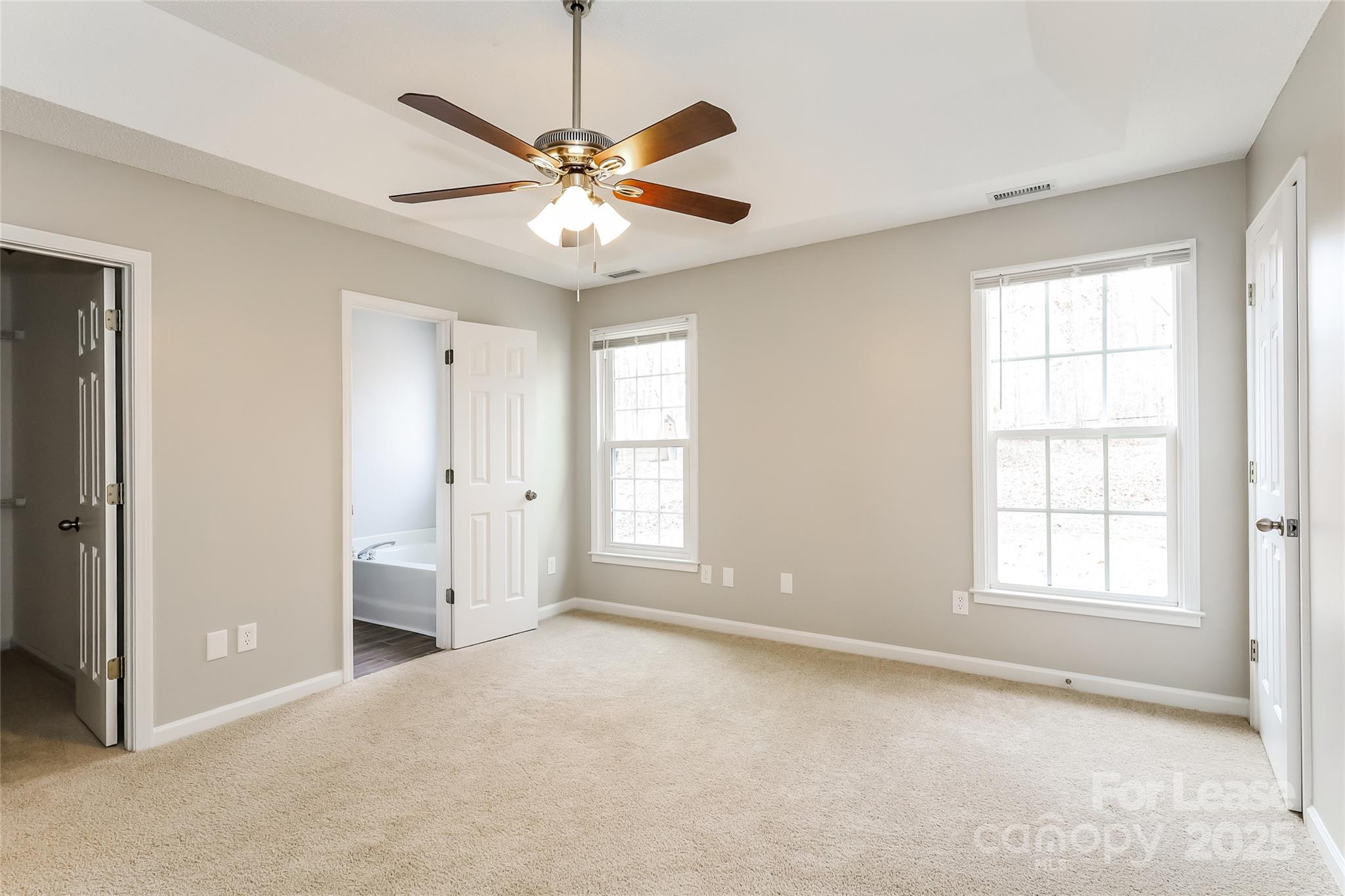 1323 Tucker Road Monroe, NC 28110 - Photo 9 of 16 an empty room with chandelier fan and windows