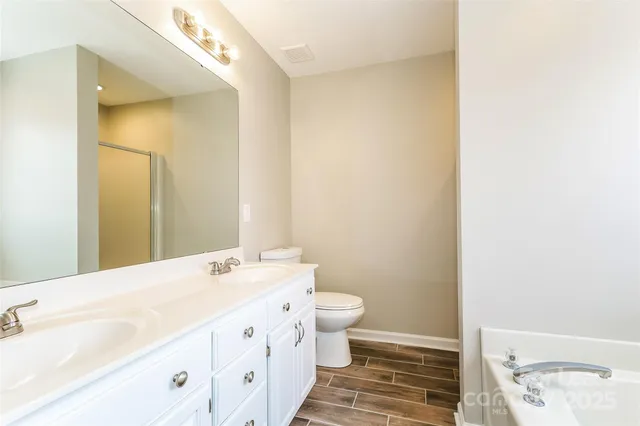 a bathroom with a double vanity sink mirror and toilet