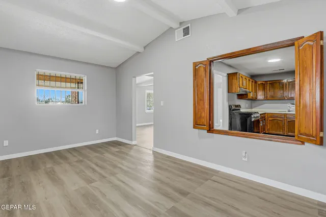 a view of a room with wooden floor and windows