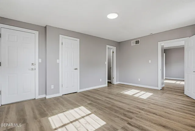 a view of an empty room and wooden floor