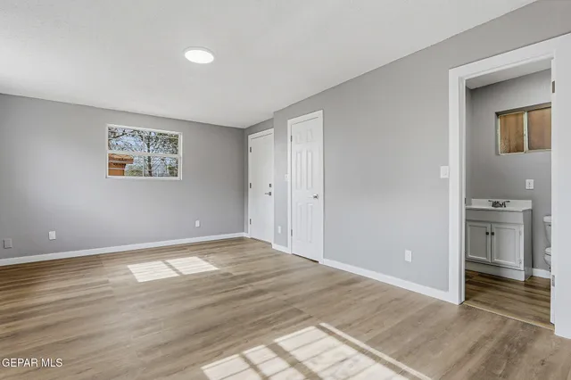 a view of an empty room and window and a kitchen