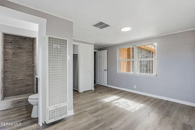 an empty room with wooden floor and windows
