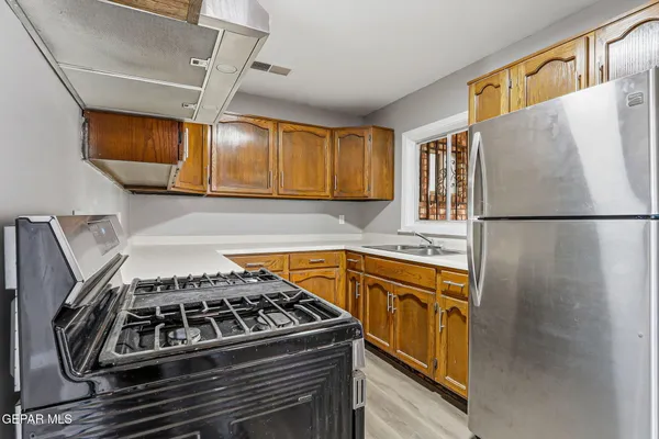 a kitchen with stainless steel appliances granite countertop a stove and a refrigerator