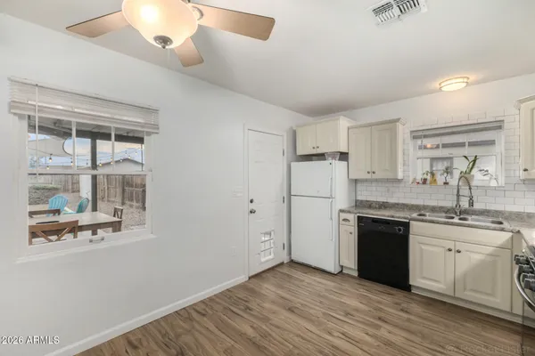 a kitchen with cabinets stainless steel appliances and wooden floor