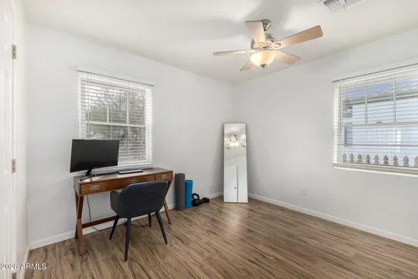 a dining room with wooden floor a chandelier a wooden table and chairs