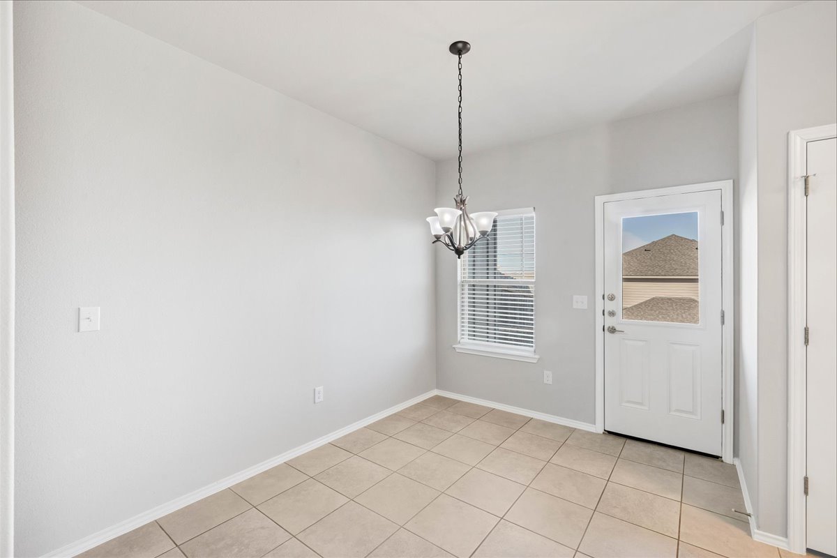 1202 Garland Road Georgetown, TX 78626 - Photo 16 of 28 Neutral-toned walls complement the tile flooring in this room featuring a window with horizontal blinds, a ceiling-mounted light fixture, and an exterior door with a window pane