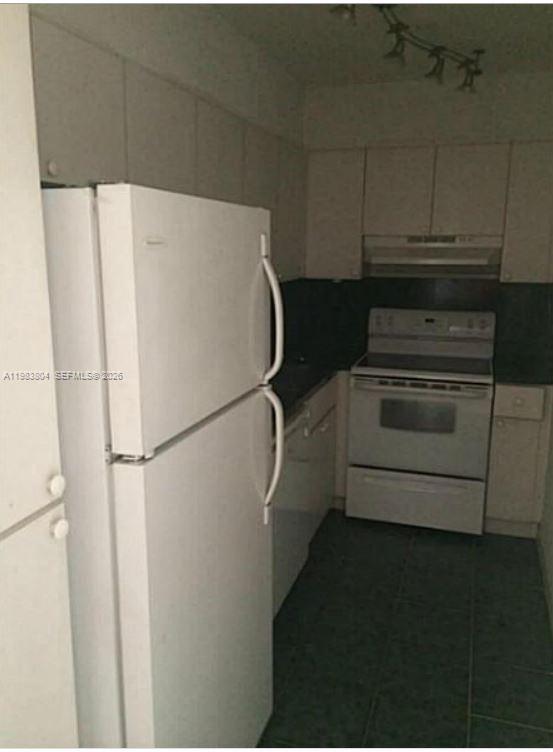 4705 Northwest 7th Street, Unit 2057 Miami, FL 33126 - Photo 4 of 9 a white refrigerator freezer and a stove sitting inside of a kitchen