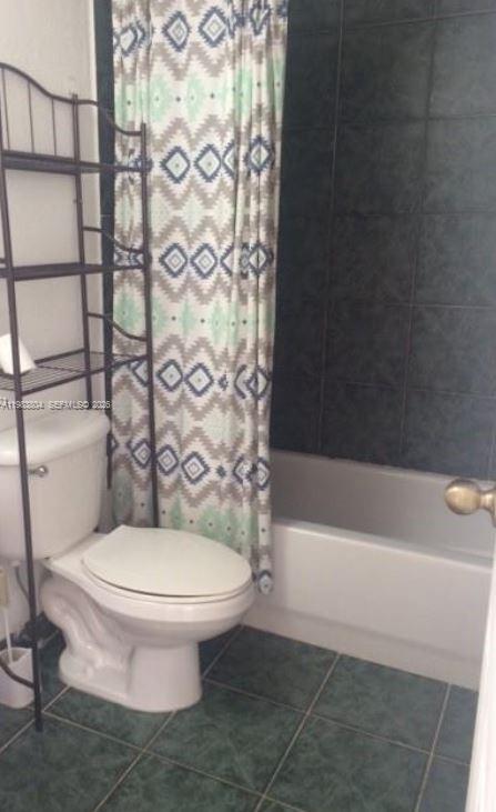 4705 Northwest 7th Street, Unit 2057 Miami, FL 33126 - Photo 6 of 9 a white toilet sitting next to a bath tub
