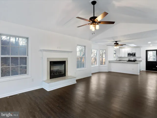 wooden floor fireplace and windows in an empty room