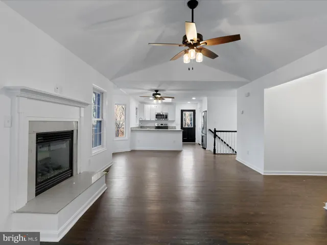 a view of a kitchen with a sink a fireplace and wooden floor