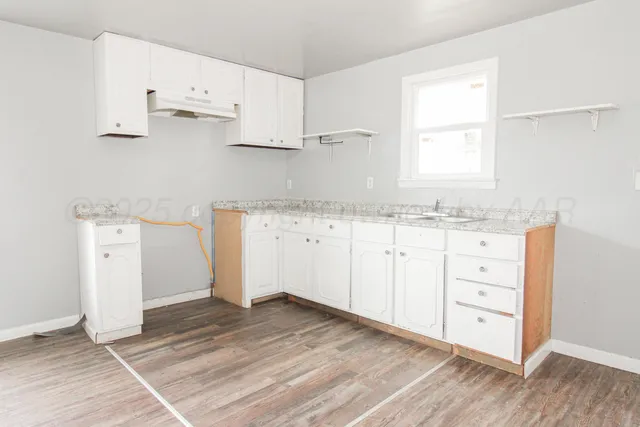 a view of cabinets a wooden floor and a window
