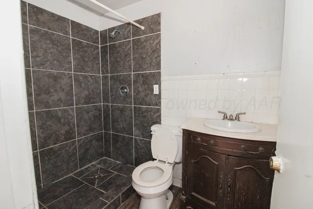 a bathroom with a toilet a sink and mirror