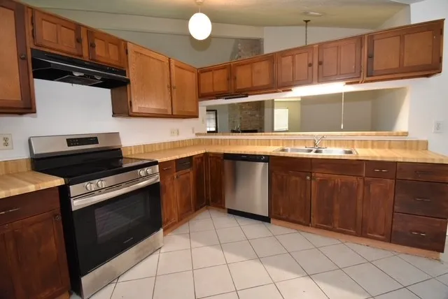 a kitchen with stainless steel appliances wooden cabinets and a sink stove