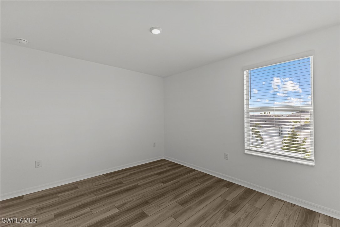 43153 Wild Indigo Road, Unit DOGWOOD Babcock Ranch, FL 33982 - Photo 11 of 20 a view of an empty room with wooden floor and a window