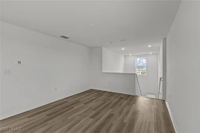 a view of a room with wooden floor and white walls