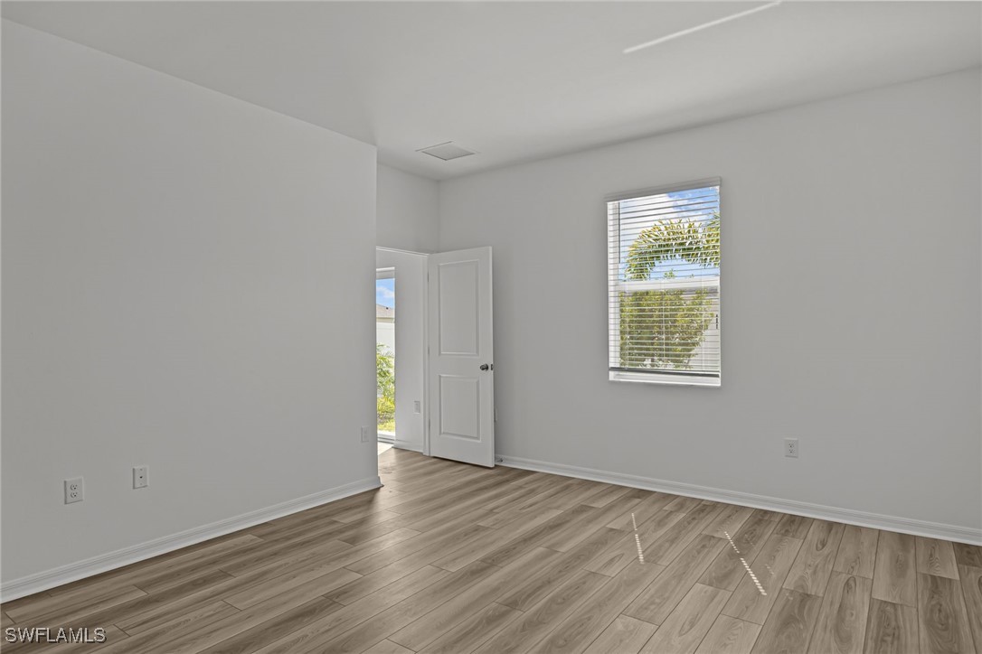 43153 Wild Indigo Road, Unit DOGWOOD Babcock Ranch, FL 33982 - Photo 6 of 20 an empty room with wooden floor and windows