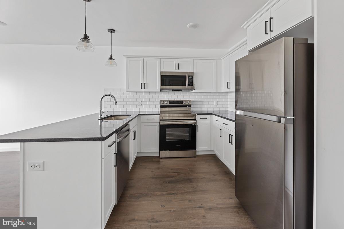 404 Fountain Street, Unit 406 Philadelphia, PA 19128 - Photo 2 of 10 a kitchen with stainless steel appliances a refrigerator stove and microwave