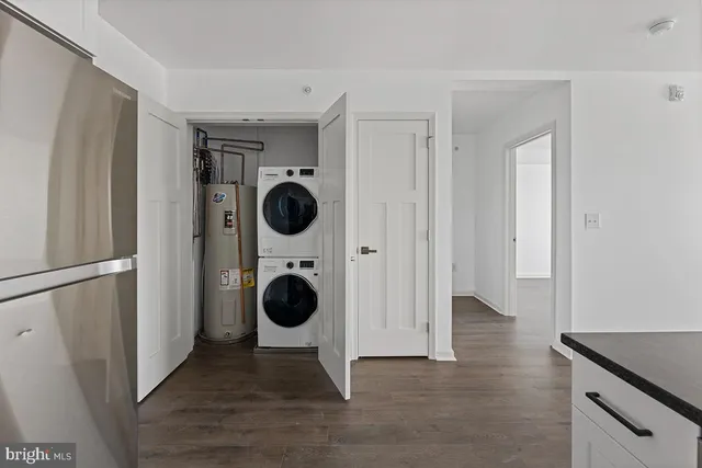 a view of a storage and utility room with wooden floor washer and dryer