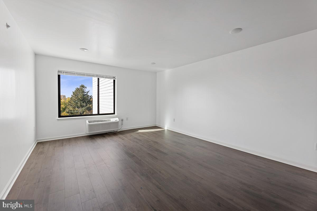 404 Fountain Street, Unit 406 Philadelphia, PA 19128 - Photo 5 of 10 a view of an empty room with wooden floor and a window