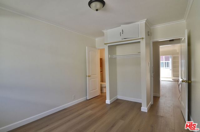 an empty room with wooden floor and closet