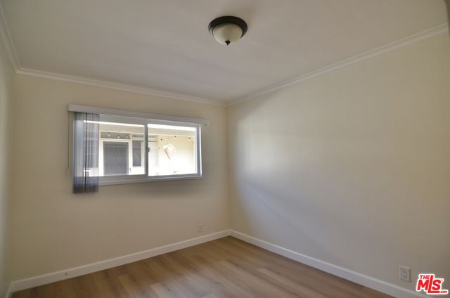 a view of a small space with wooden floor and a window
