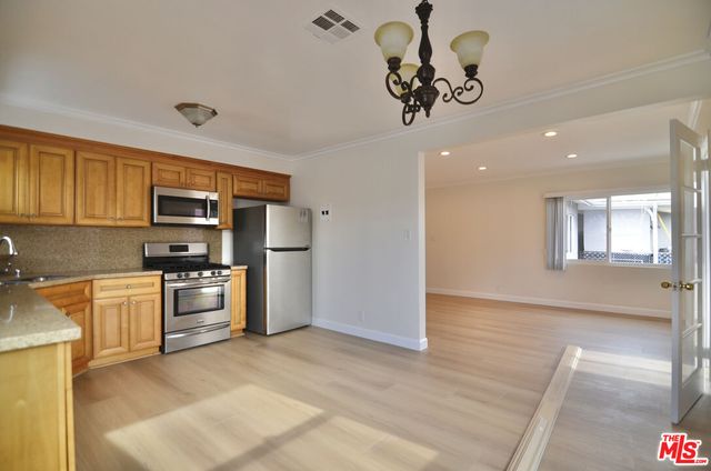 a kitchen with stainless steel appliances granite countertop a refrigerator and a stove top oven