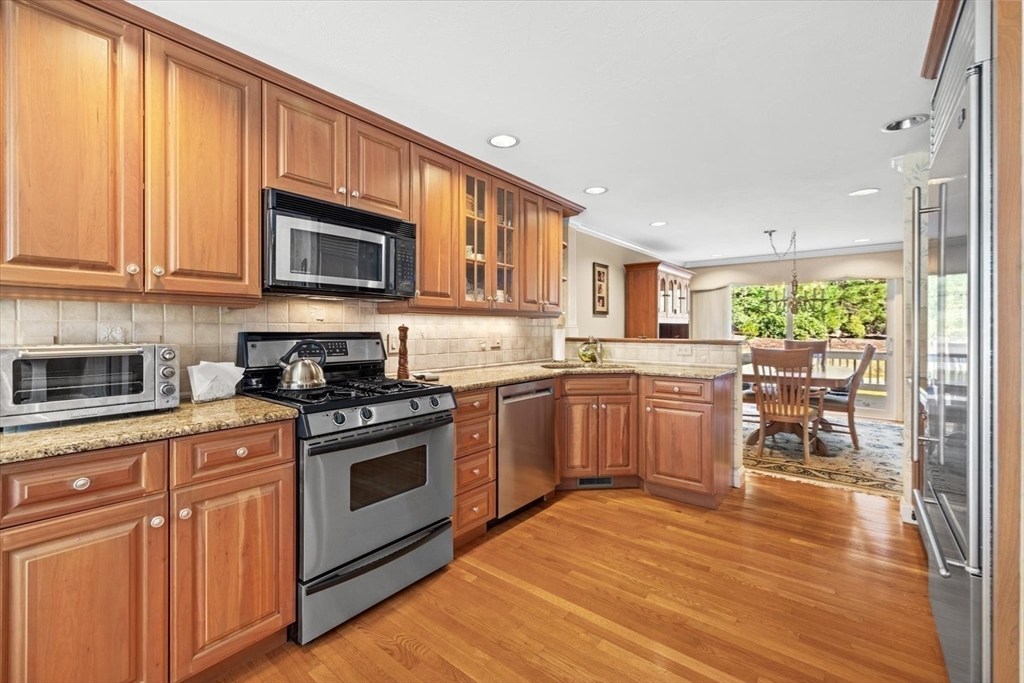 55 Bay Farm Road, Unit 55 Duxbury, MA 02332 - Photo 12 of 37 a kitchen with stainless steel appliances granite countertop a stove top oven a sink dishwasher and a refrigerator with wooden floor