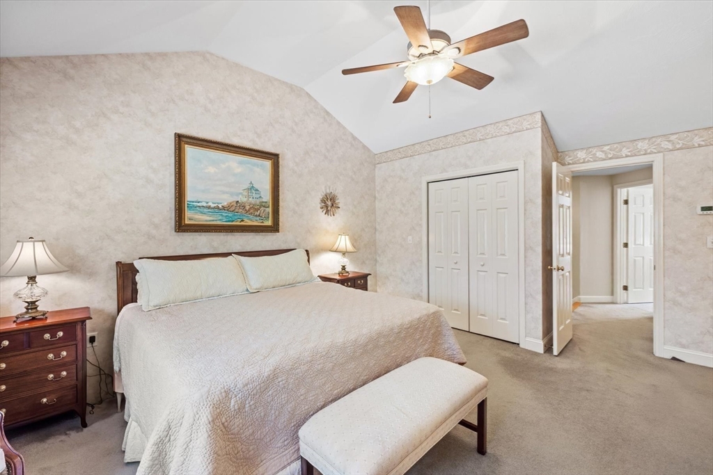 55 Bay Farm Road, Unit 55 Duxbury, MA 02332 - Photo 18 of 37 a spacious bedroom with a bed and a chandelier