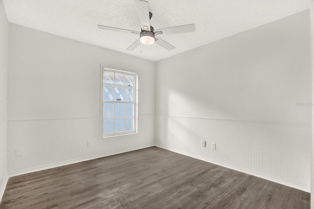 1712 Elk Spring Drive Brandon, FL 33511 - Photo 12 of 21 an empty room with wooden floor chandelier fan and windows