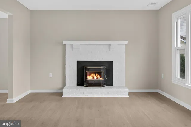 an empty room with a fireplace and a window